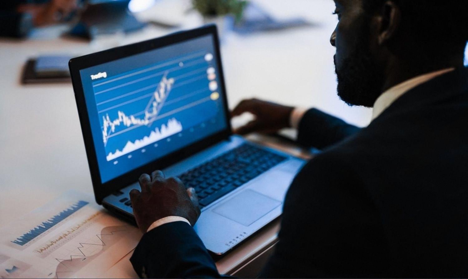 Manager monitoring operational data dashboards on a laptop in a UAE office